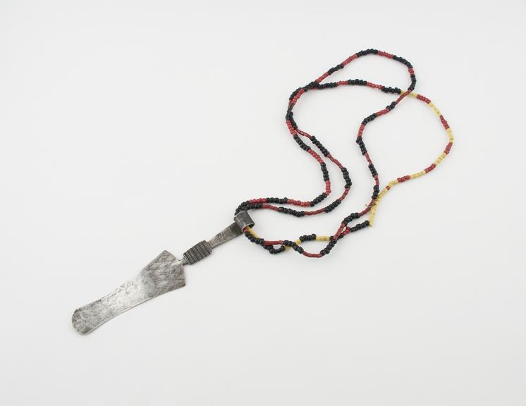 Steel strigil, with looped end suspended from bead sling