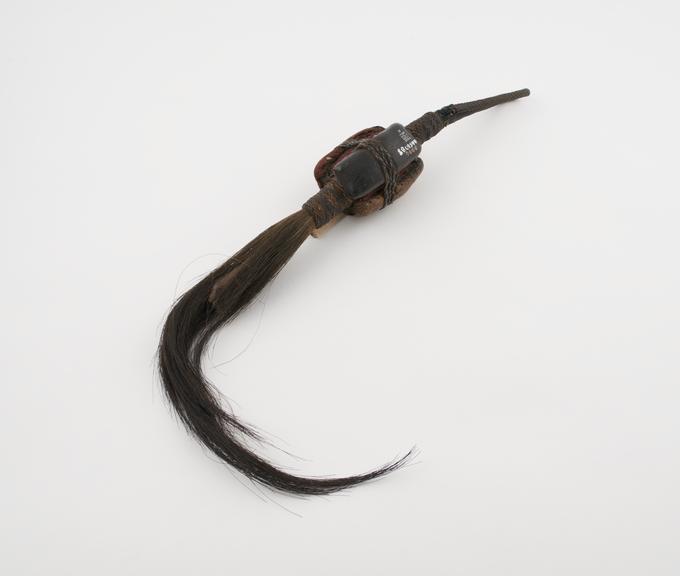 Amulet in form of fly whisk surmounted by three leather covered