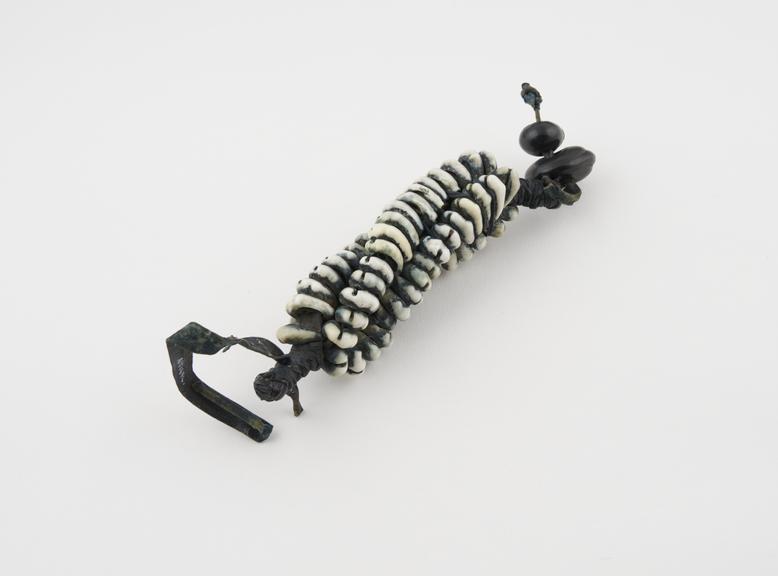 Amulet made from strands of cowrie shell threaded on leather