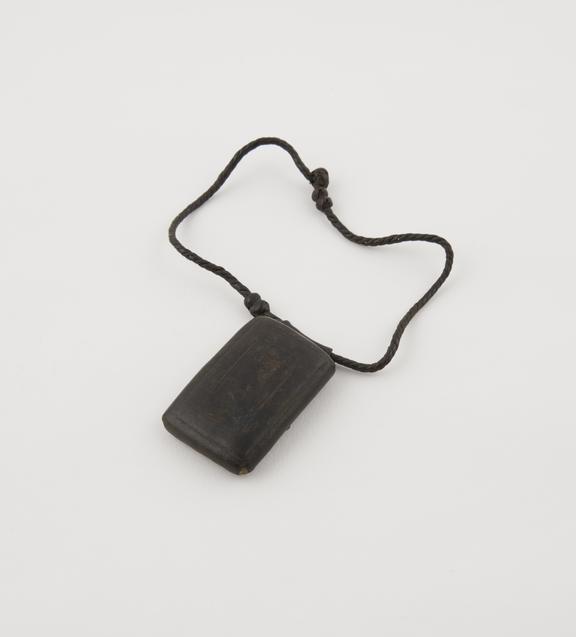 Rectangular leather amulet case, attached to leather thong