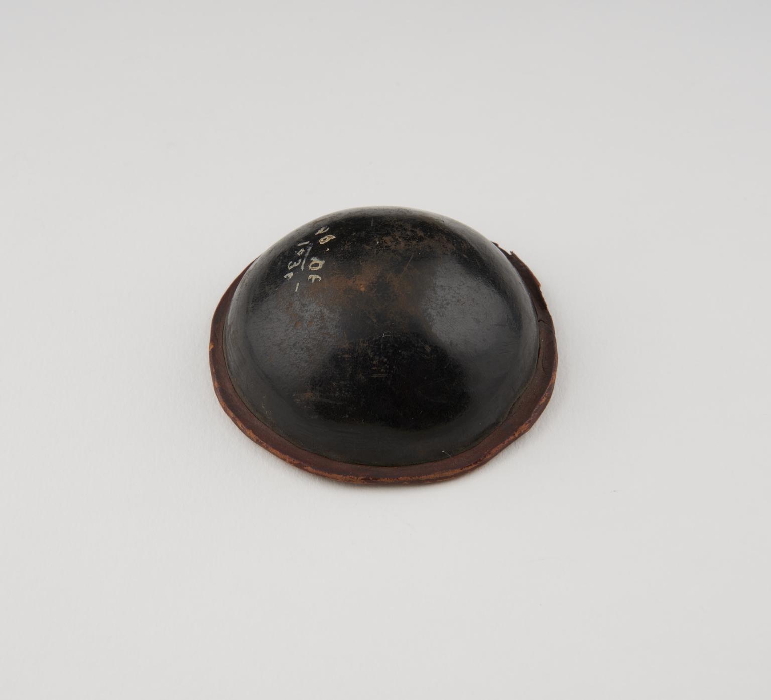 Domed leather button shaped object | Science Museum Group Collection