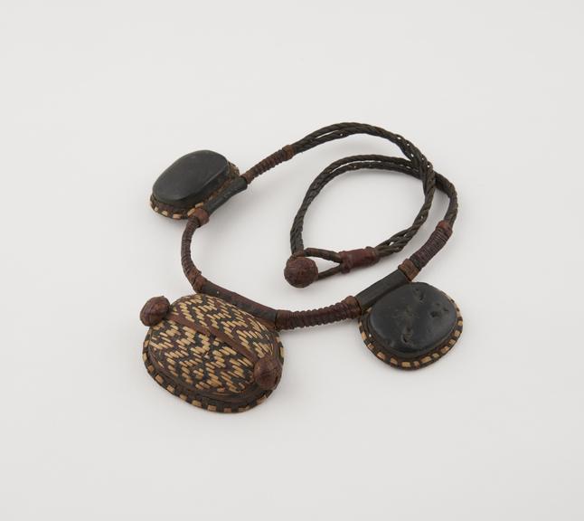 Amuletic necklace, three amulet cases on leather thong