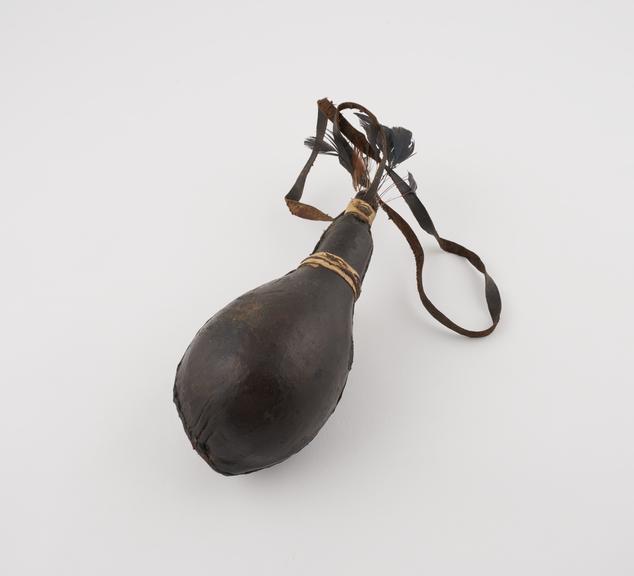 Gourd covered with black leather and suspended from leather