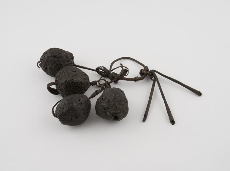 Amuletic rattle consisting of iron rods and large nuts threaded