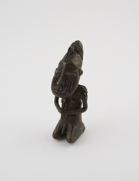 Brass statue of kneeling male figure holding object in hands