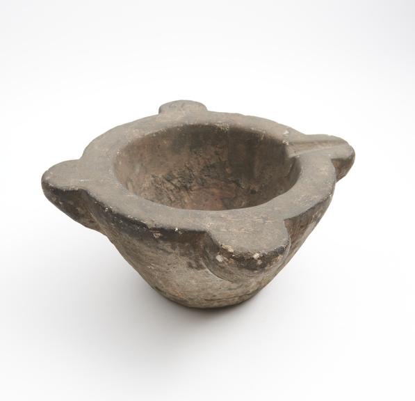 Large bowl-shaped stone mortar, with 4 lugs on rim