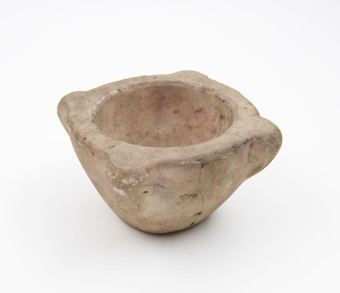 Small bowl-shaped mortar with four lugs on rim, in white stone