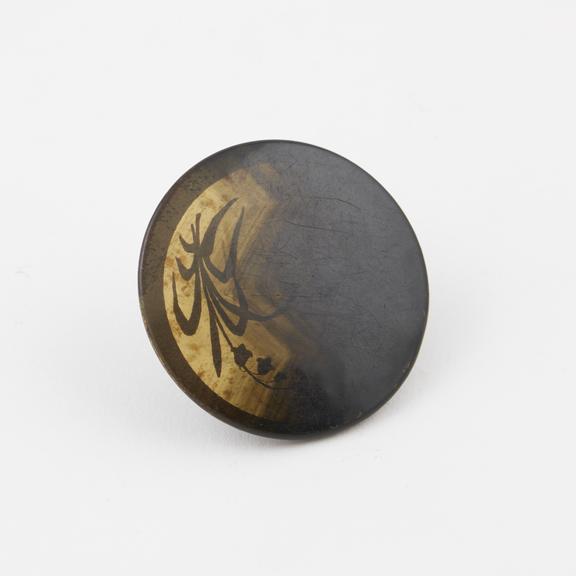 Circular button of cellulose nitrate covered metal painted with