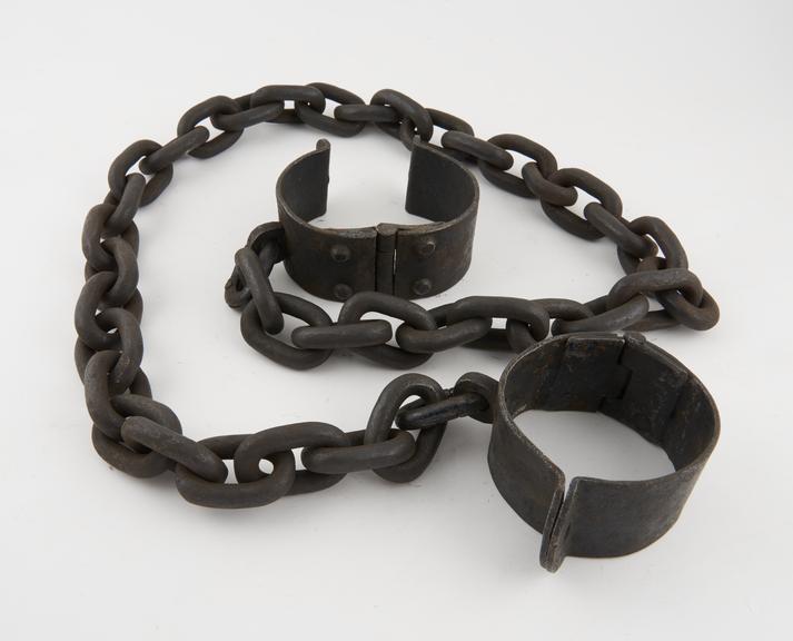 Pair of leg irons, wide cuffs linked by iron chain