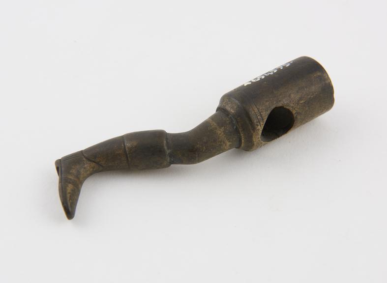 Brass tamper in the form of a booted leg bent at the knee