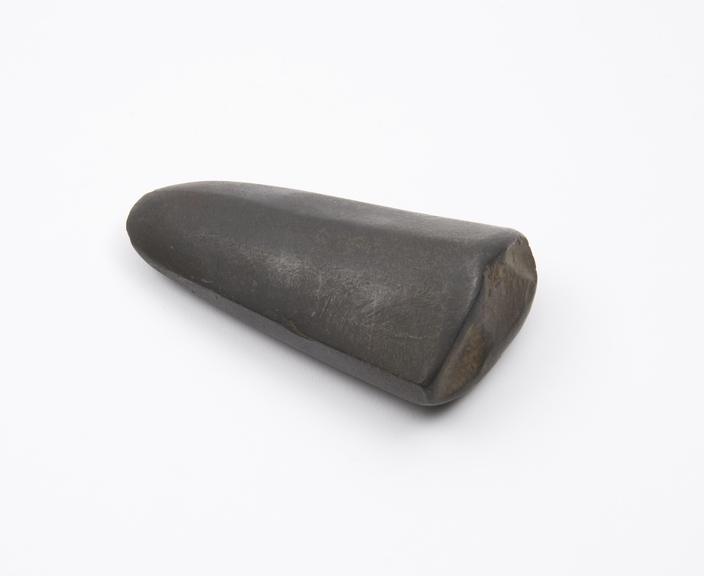 Solid black stone pounder resembling axe-head in shape