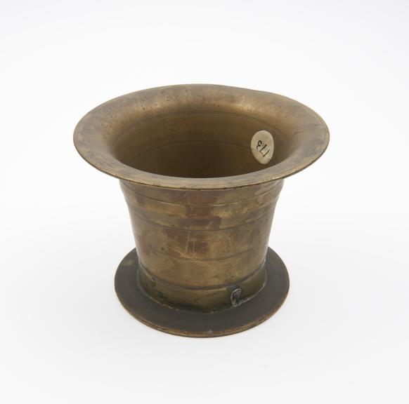 Bell shaped brass mortar with wide flat base, everted rim