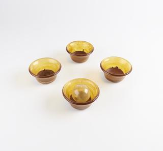 Four glass bowls with a residue, one with glass ball