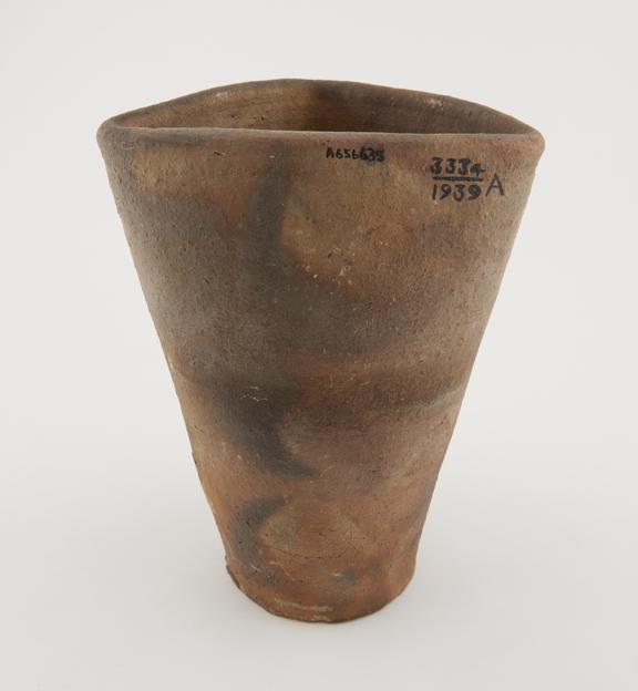 Tall terracotta crucible with triangular rim and circular base