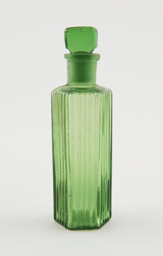 Hexagonal green glass bottle with tall neck and stopper