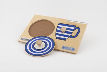 Wooden puzzle board showing a cup and saucer