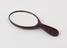 Hand mirror with oval frame and handle with curved end made of