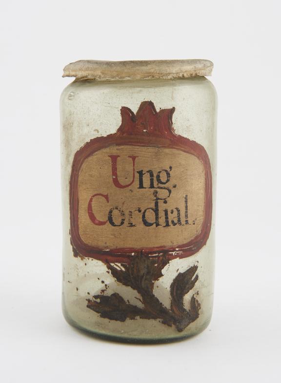 Glass drug jar, cylindrical, with parchment cover, labelled Ung