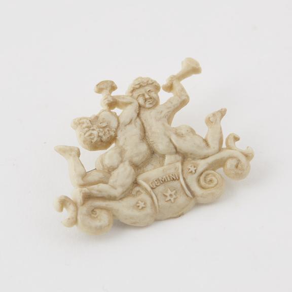 Brooch showing pair of cherubs with trumpets cavorting on cloud