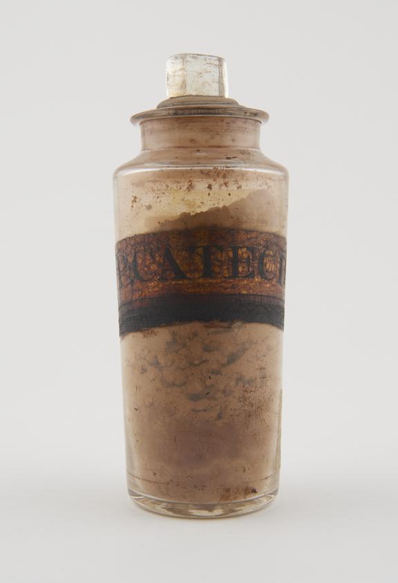 Bottle, cler glass, with contents, for powdered catechu