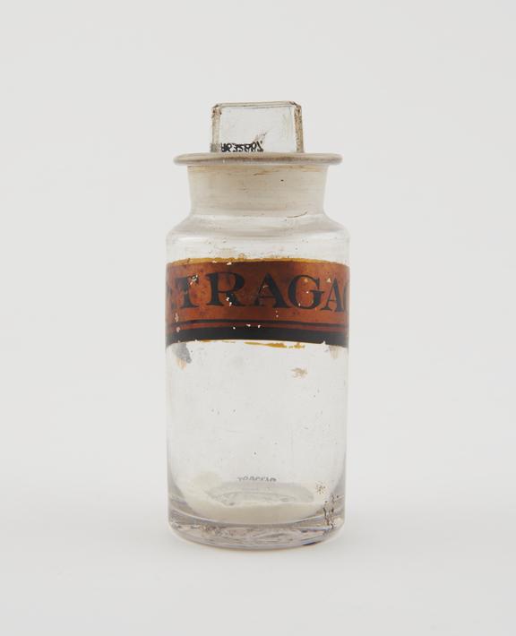 Bottle, clear glass, with contents, for powdered tragacanth