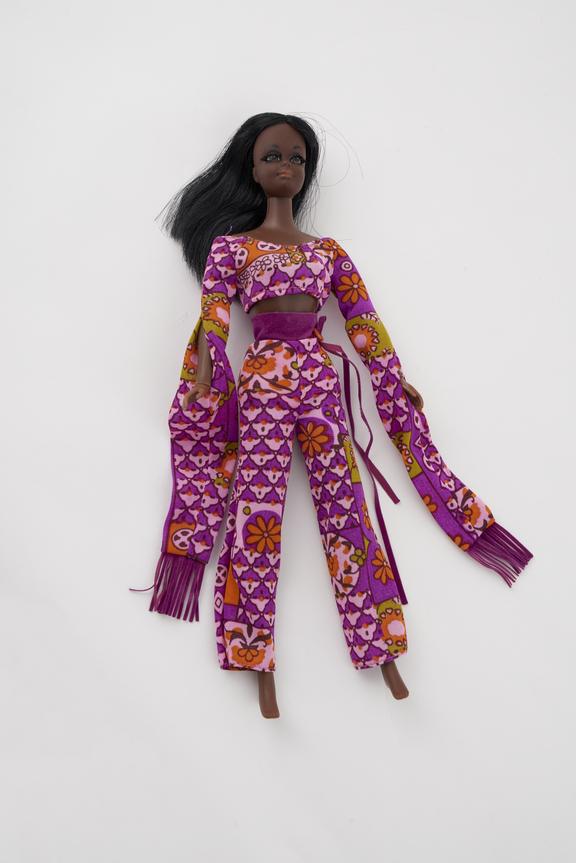 Black Barbie with purple patterned suit, long sleeves.