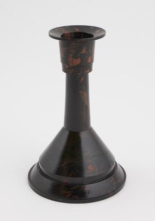 One of two phenolic brown mottled candlesticks