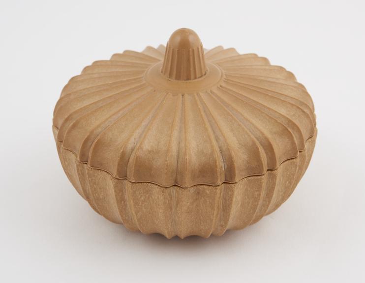 Circular box in Indian style, of sandy-coloured plastic