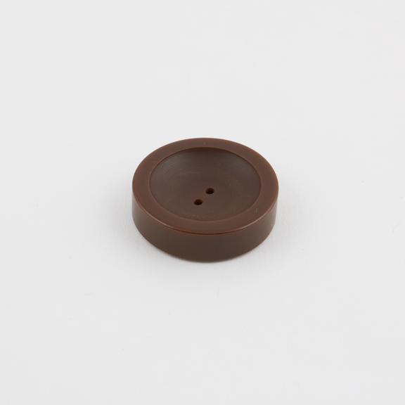 Circular button of brown cast phenolic