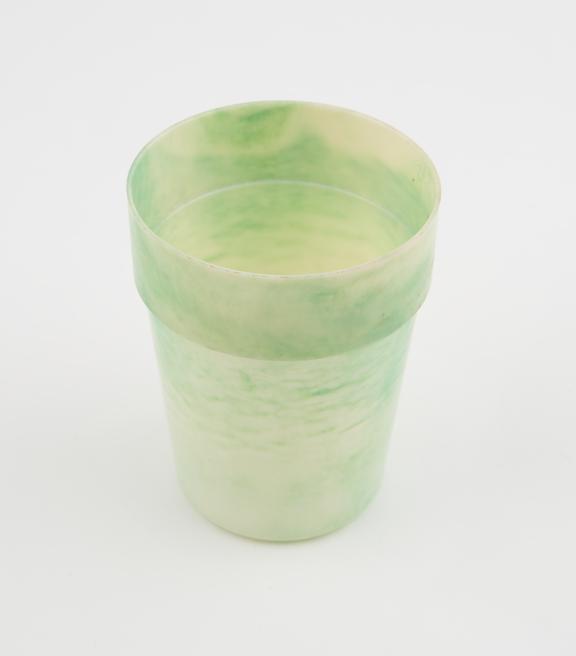 Circular beaker of pale green marbled with deep green urea