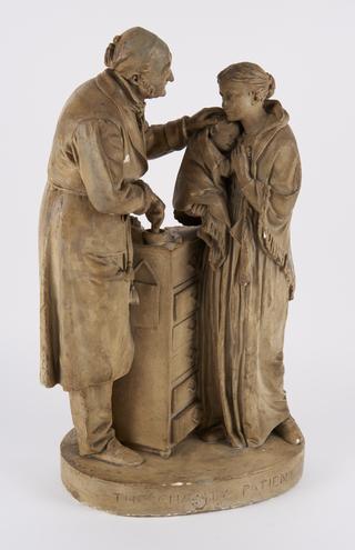 Statue showing a doctor treating a poor person