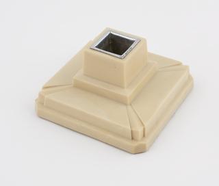 One of two square candlesticks of ivory urea formaldehyde