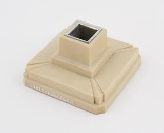 One of two square candlesticks of ivory urea formaldehyde