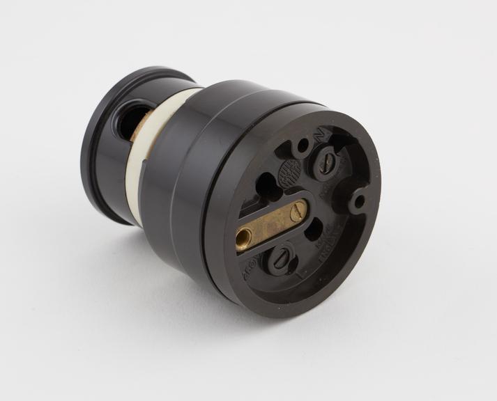 Circular brown phenolic electric plug and socket (plugged