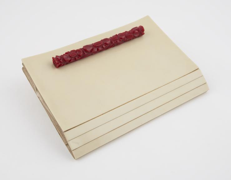 Hand bag of cream urea formaldehyde with red moulded handle