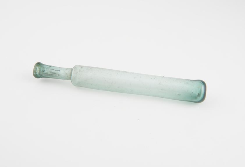 Green glass phial, in the shape of an elongated cylinder