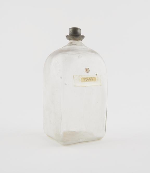 Square storage bottle, clear glass, empty, possibly Swiss