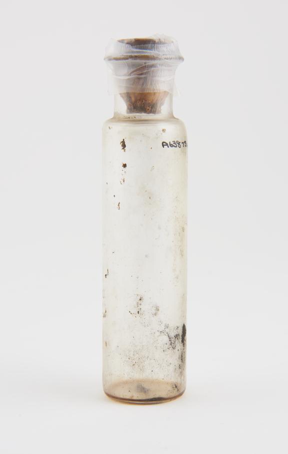 Cylindrical clear glass bottle with cork, empty