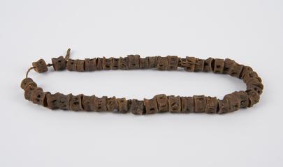 Amuletic necklace of snake vertebrae threaded onto string