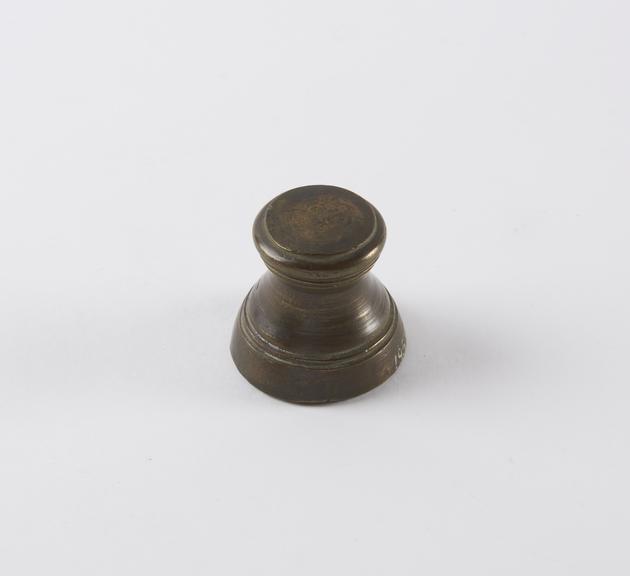 One of eight Indian brass weights, stool shaped