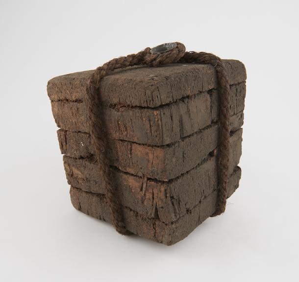 Weight comprising five cork slabs bound together with rope