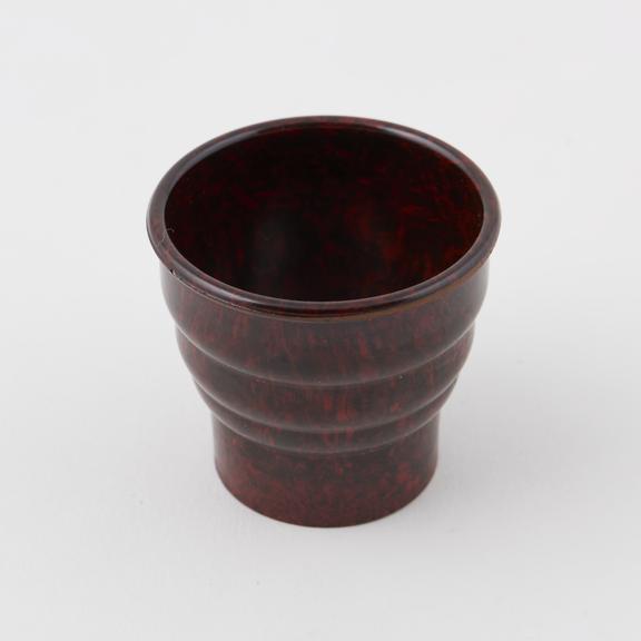 Egg cup made of mottled dark brown/reddish brown phenolic