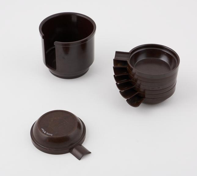 Set of circular ashtrays stacked in cylindrical  holder