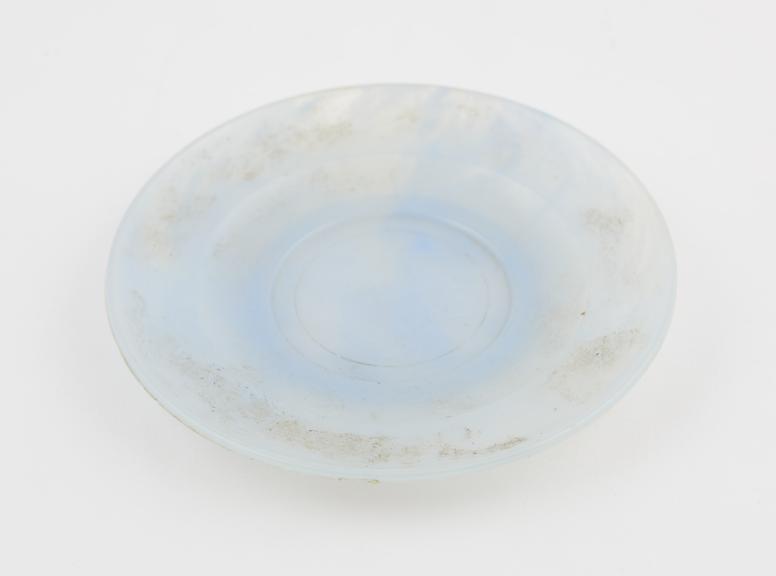 Circular saucer of pale blue and clear marbled polystyrene