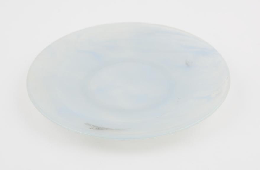 Circular plate of pale blue and clear marbled polystyrene