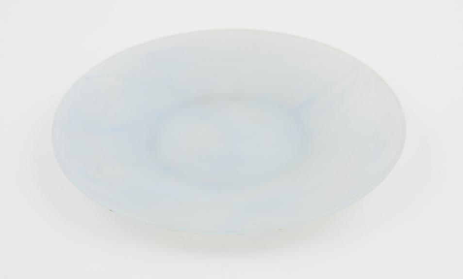 Circular plate of pale blue and clear marbled polystyrene