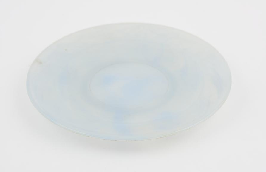 Circular plate of pale blue and clear marbled polystyrene