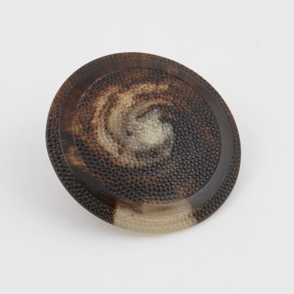 Circular button of imitation tortoiseshell acrylic? surface