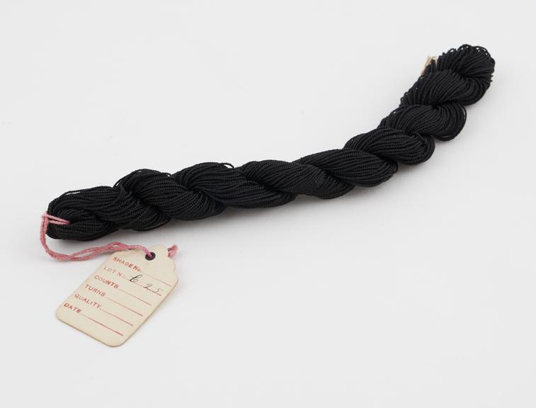 Black viscose skein,  coarse yarn,  plaited. Labelled SHADE No.