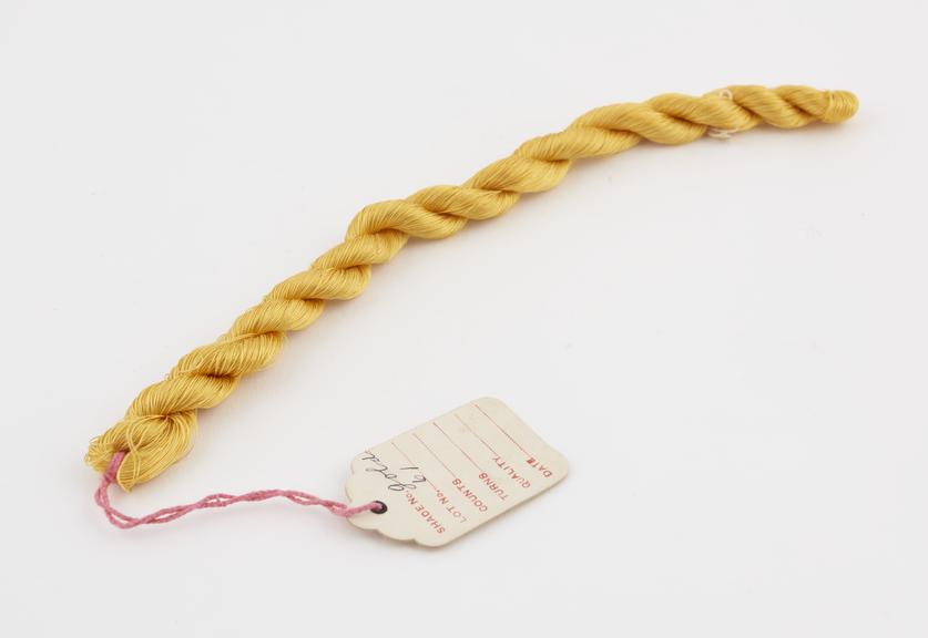 Skein of golden yellow viscose, plaited, labelled SHADE No
